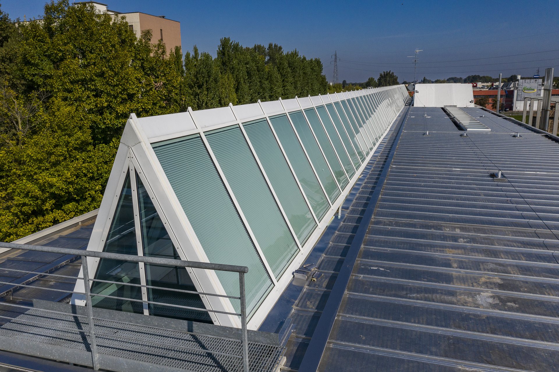 Vista dal drone della copertura: la fila continua di lucernari vetrati con le veneziane dentro il vetro